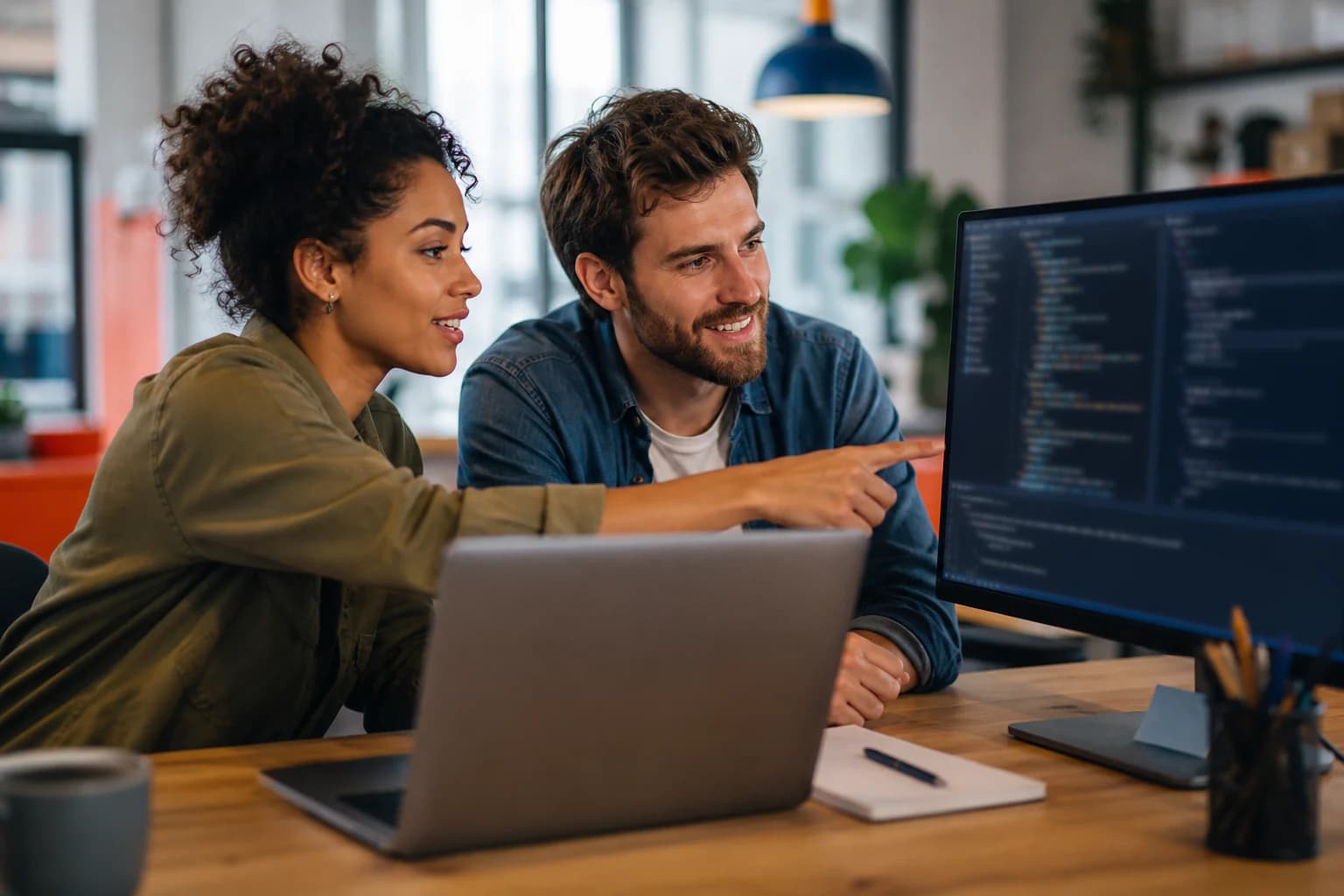Two developers collaborating on software with AI assistance